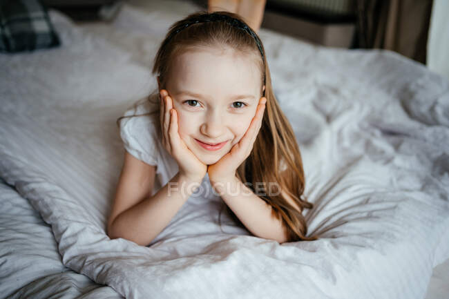 Chica acostada en la cama - foto de stock