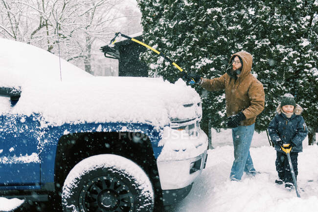 Pai e filho limpando a neve juntos na entrada da garagem em Massachusetts — Fotografia de Stock