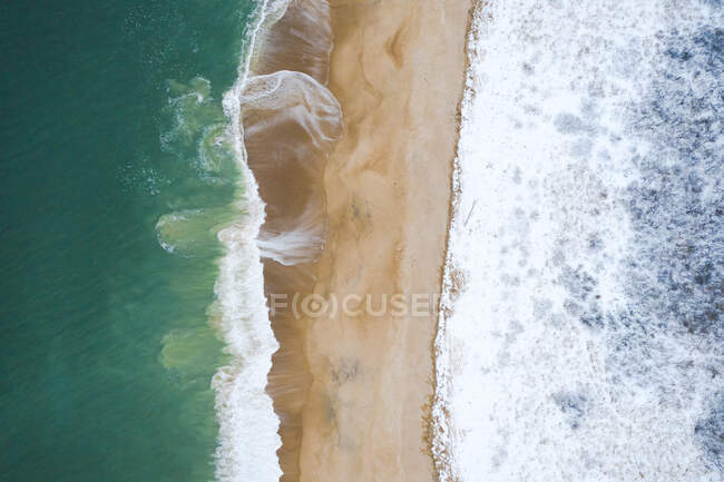 Воздушный вид на пляж с волнами и морем — стоковое фото