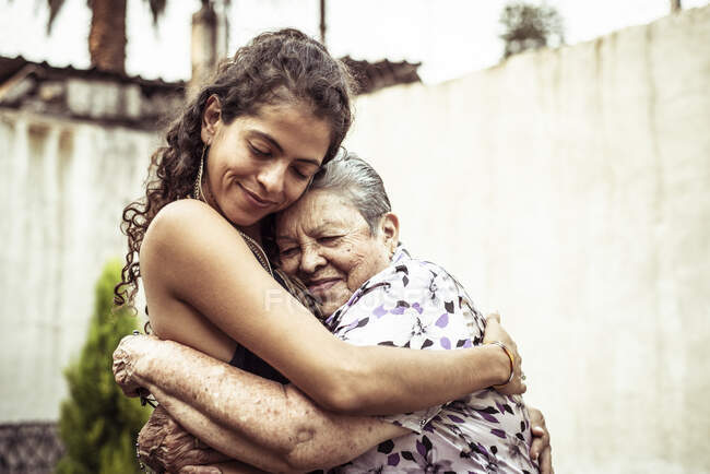 Mexican women smile in loving hug embrace on summer street Mecxico — Stock Photo