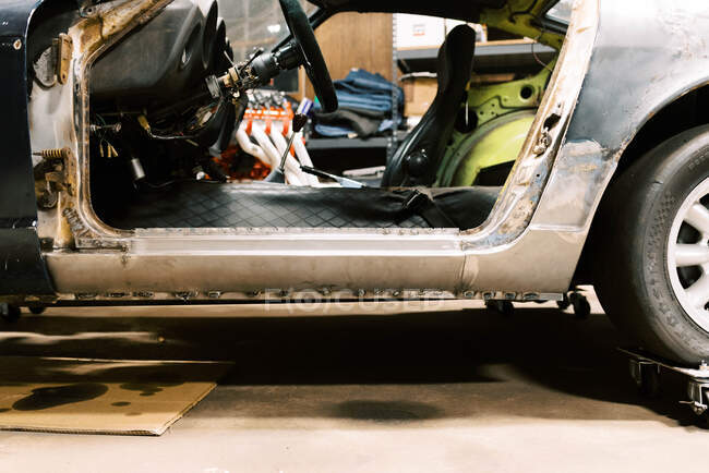 Старый автомобиль в гараже получает ржавчины повреждения ремонта и панелей фиксированной — стоковое фото