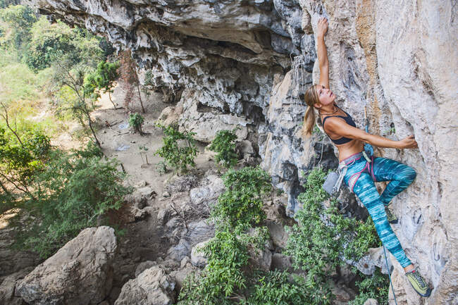 Frau erklimmt steile Kalksteinklippe in Laos — Stockfoto