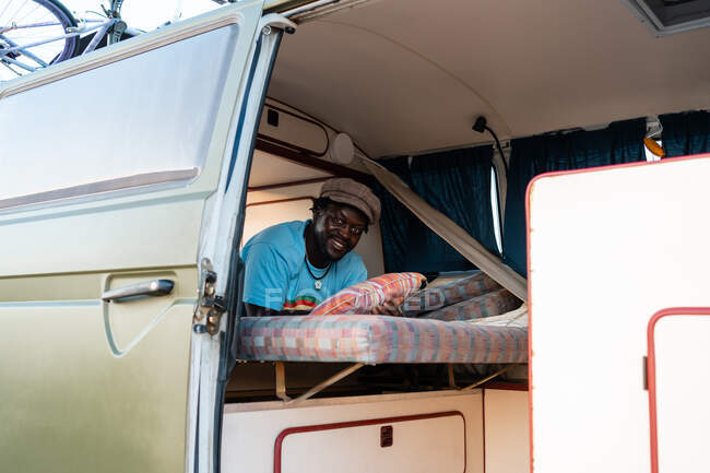 Чорний афроамериканець в своєму фургоні для кемпінгу, свобода і три — стокове фото