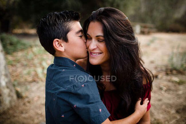 Filho beijando a mãe na bochecha em San Diego — Fotografia de Stock