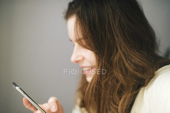 Mujer usando smartphone en casa - foto de stock