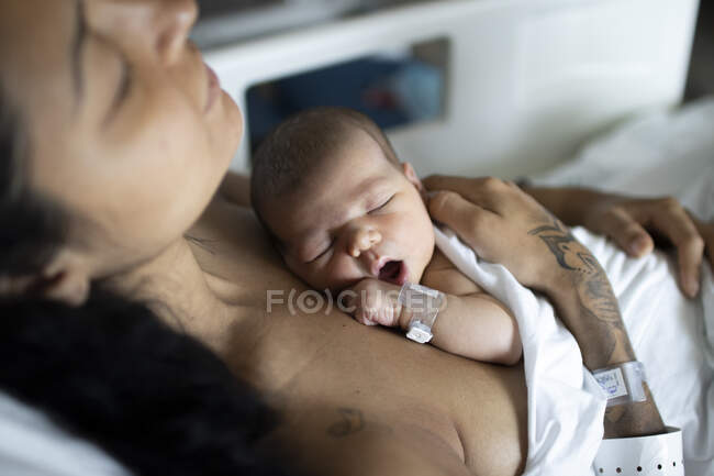 Um recém-nascido com sua jovem mãe no hospital tendo um descanso. — Fotografia de Stock