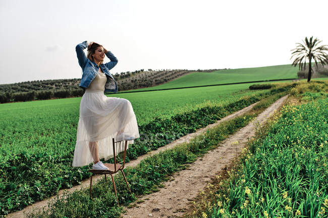 Молодая девушка в платье позирует в поле — стоковое фото