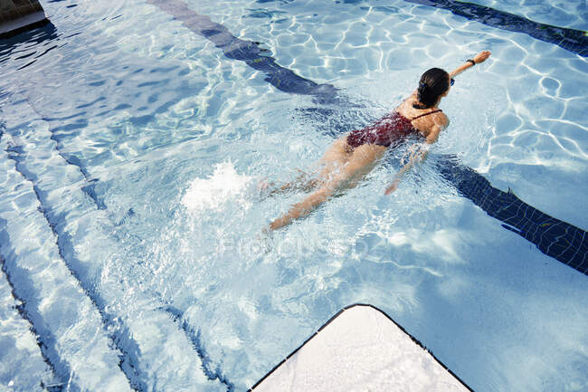 Femme nageant dans la piscine. Vue grand angle — Photo de stock
