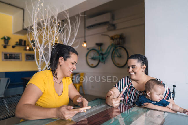 Дві жінки в кафе розмовляють і сміються — стокове фото