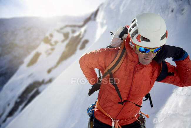 Ice Climber fixing his pack before ice climbing — Stock Photo
