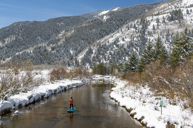 Frau paddelt im Winter auf Fluss — Stockfoto
