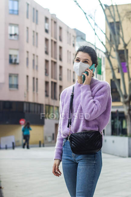 Young woman with mobile phone in city — Stock Photo