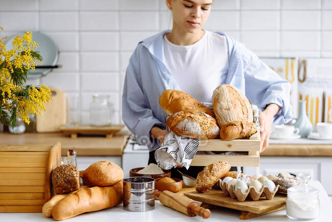 Giovane ragazza che tiene il pane in cucina — Foto stock