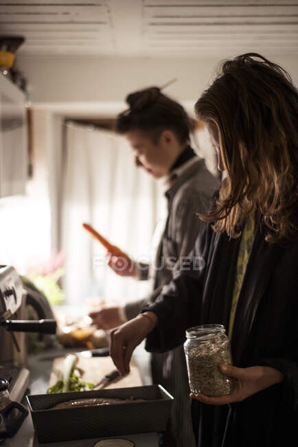Queer mulheres casal cozinhar jantar saudável em casa juntos na europa — Fotografia de Stock
