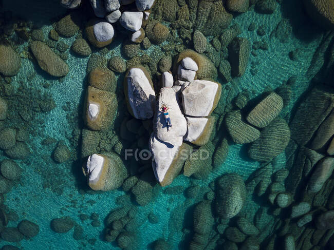 Vista aérea fêmea deitado na rocha no lago tahoe — Fotografia de Stock