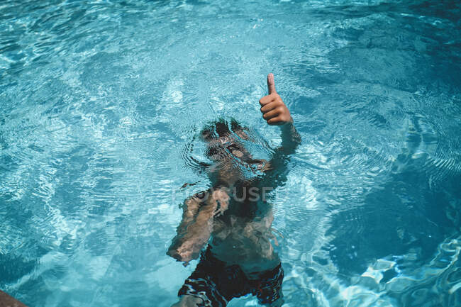 Menino dá um polegares até enquanto segurando respiração subaquática — Fotografia de Stock