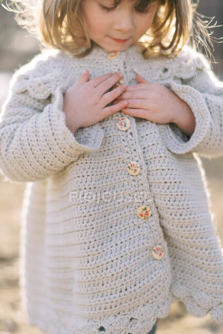Pequena menina de três anos usando caseiro crochê casaco de lã na primavera — Fotografia de Stock