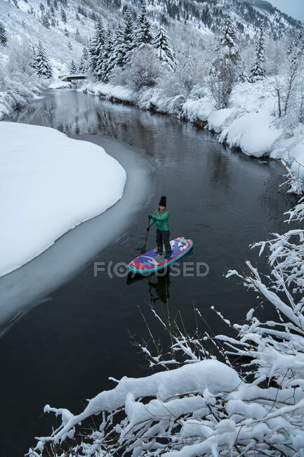 Frau paddelt im Winter auf Fluss — Stockfoto