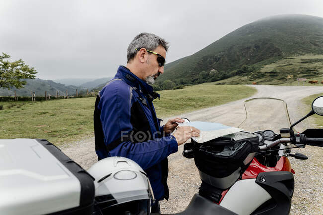 Male driver  with motorcycle on road trip — Stock Photo