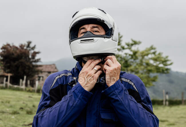 Portrait of a young man in a helmet  on a background of a field — Stock Photo