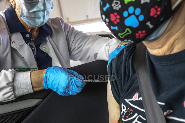 A nurse prepares to administer at a  Covid 19 Vaccine to a 74 year old woman at a drive-thru  distribution center in Hoover, Alabama organized by the University of Alabama, Birmingham, UAB. — Stock Photo