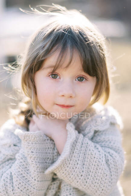 Портрет маленькой девочки на закате в вязаном кардигане — стоковое фото
