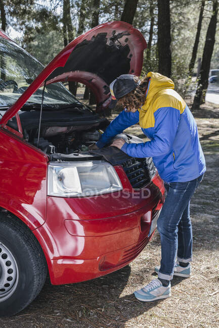 Man checking the van engine before driving it on the road during a tri — Stock Photo