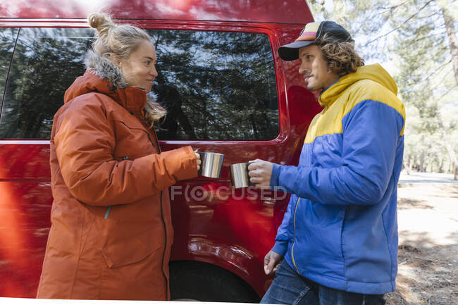 Пара розслабляється з гарячим напоєм під час перерви від поїздки у кемперу . — стокове фото