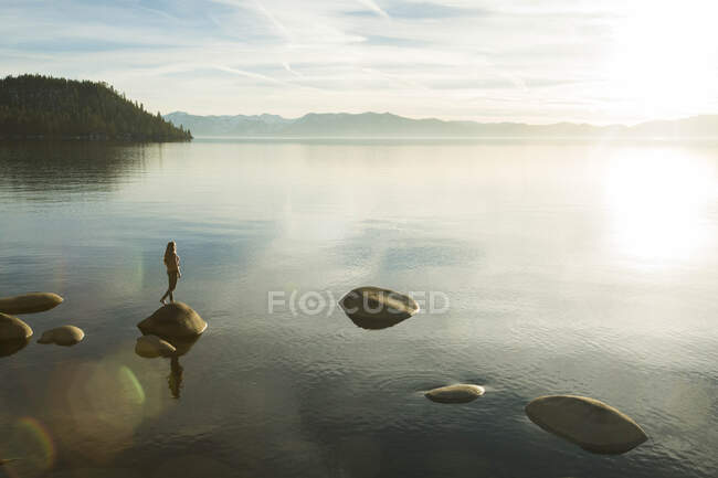 Feminino em pé na rocha no Lago Tahoe — Fotografia de Stock