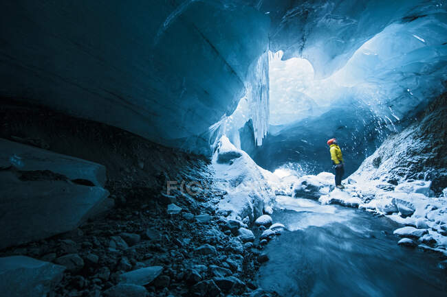 Hombres explorando la cueva de hielo en Thrsmrk - Islandia - foto de stock