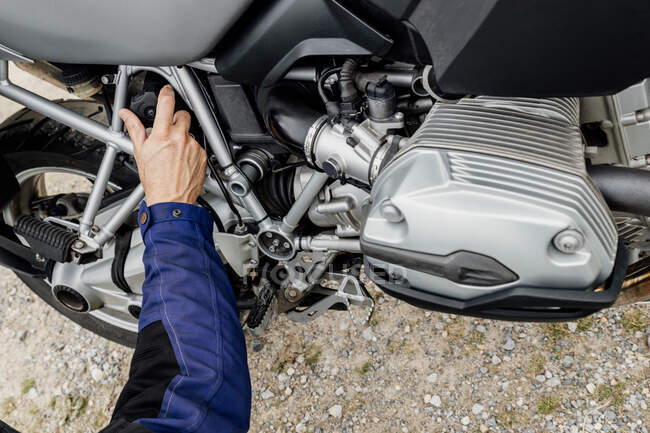 A motorcycle and male hand  on a sunny spring day. — Stock Photo