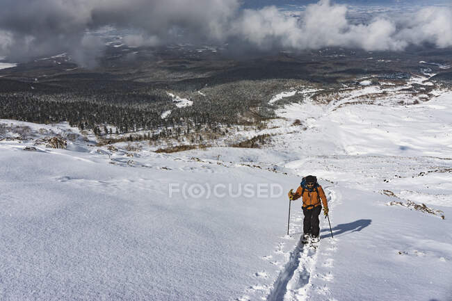Мужчина, разделяющийся на снежной горе — стоковое фото