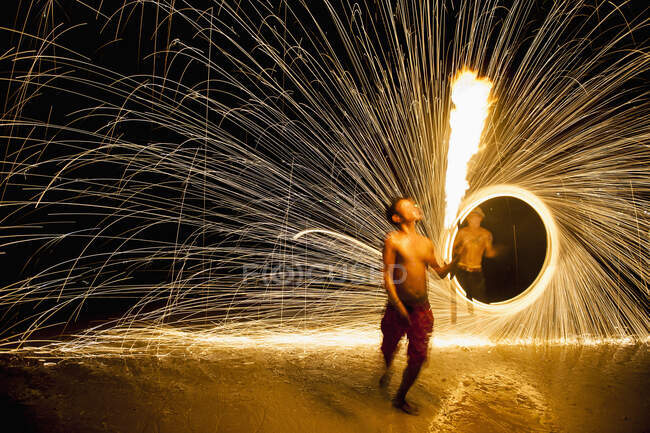 Огненная танцовщица выступает на пляже в Рэйли — стоковое фото