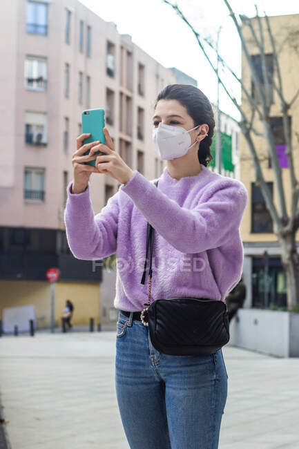 Jeune femme avec téléphone portable en ville — Photo de stock
