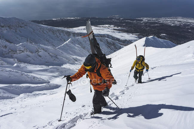 Люди со спуском на лыжах на заснеженной горе — стоковое фото