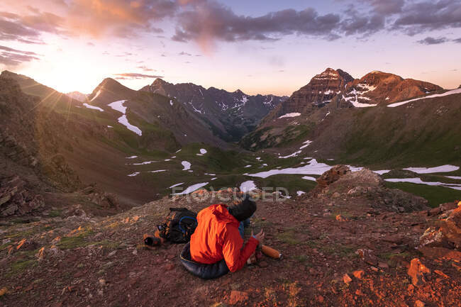 Escursionista femminile seduta sulla montagna contro il cielo durante il tramonto — Foto stock