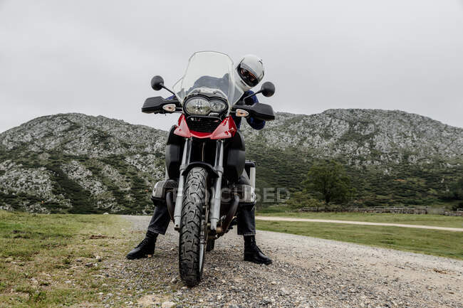Людина з мотоциклом в сільській місцевості — стокове фото