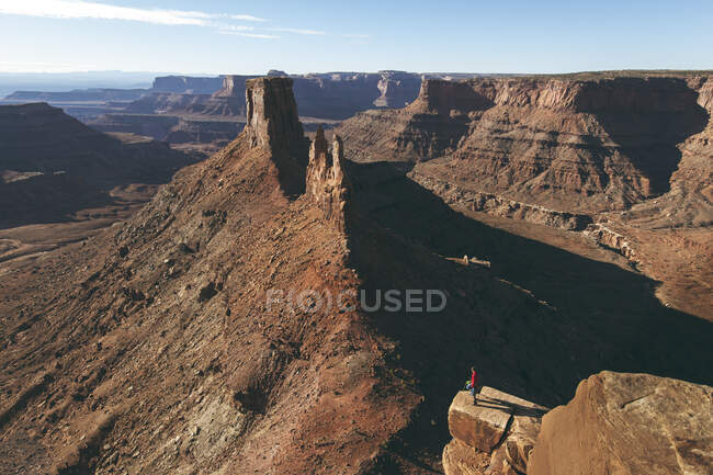 Uomo in piedi su una scogliera rocciosa al Parco Nazionale Canyonlands — Foto stock