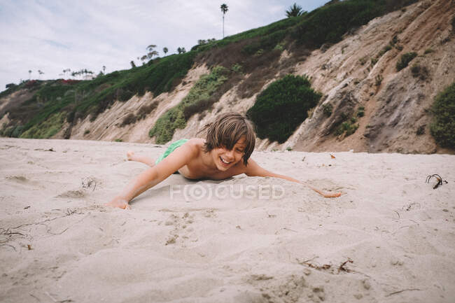 Хлопець грає на теплому піску на пляжі в Каліфорнії. — стокове фото