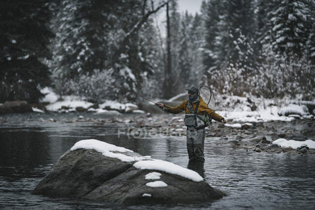 Mann beim Fliegenfischen im Winter im Fluss stehend — Stockfoto