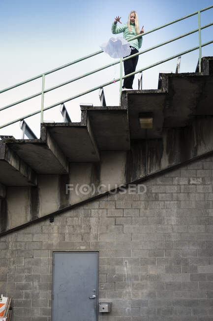 Дівчинка скидає парашут зі сходів на стадіоні — стокове фото