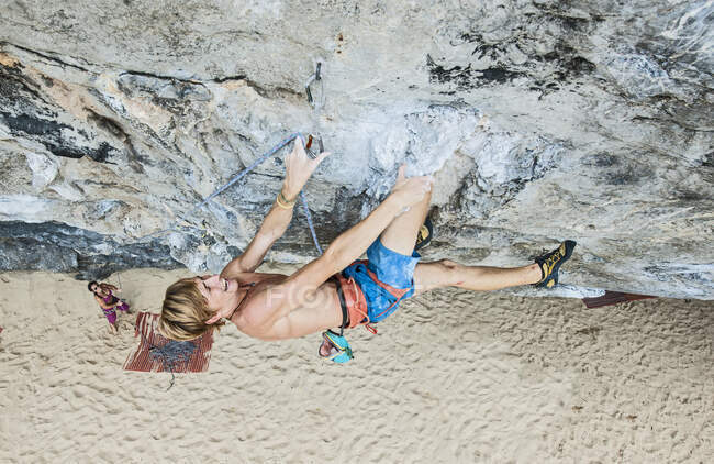 Giovanotto arrampicata strapiombante faccia di roccia a tonsai spiaggia — Foto stock