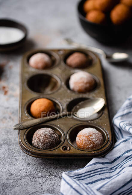 Magdalenas de chocolate con nueces y azúcar en polvo sobre un fondo oscuro. - foto de stock