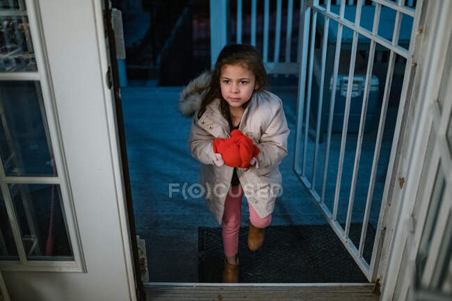 Niño entrando por la noche después de jugar en clima frío - foto de stock
