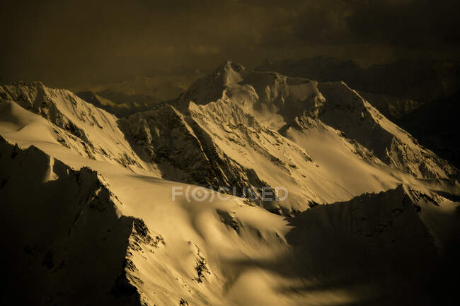 Vue panoramique de la chaîne de montagnes enneigées au coucher du soleil — Photo de stock