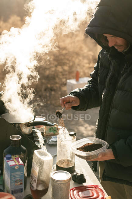 Человек готовит кофе, исследуя национальный парк Каньонлендс во время отпуска — стоковое фото