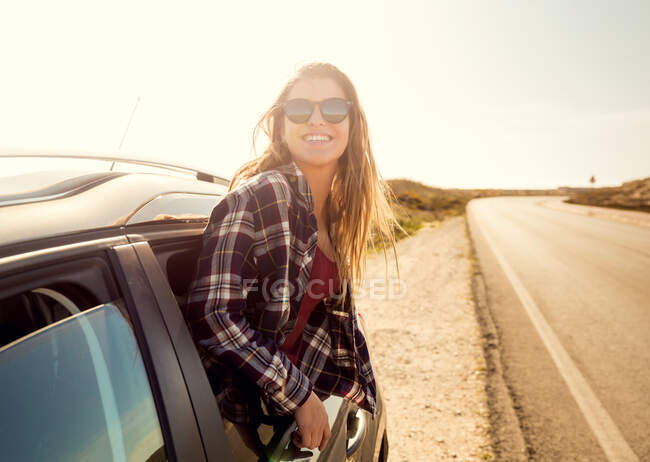 Glückliches Mädchen schaut aus dem Autofenster — Stockfoto