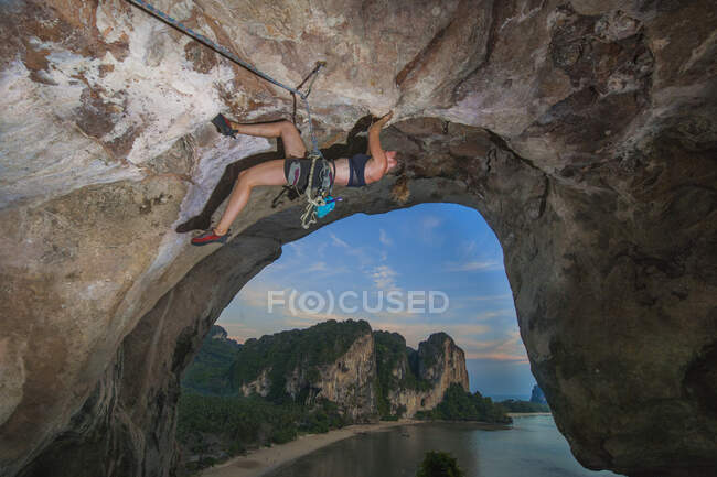 Junge Frau klettert überhängende Felswand am Tonsai-Strand — Stockfoto