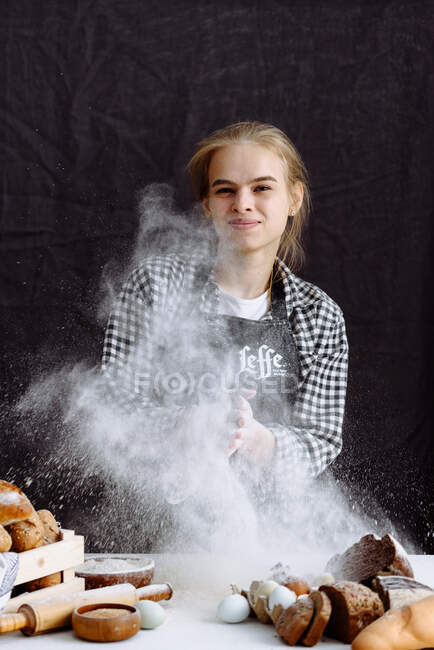 Chica hace masa de pan en una cocina - foto de stock