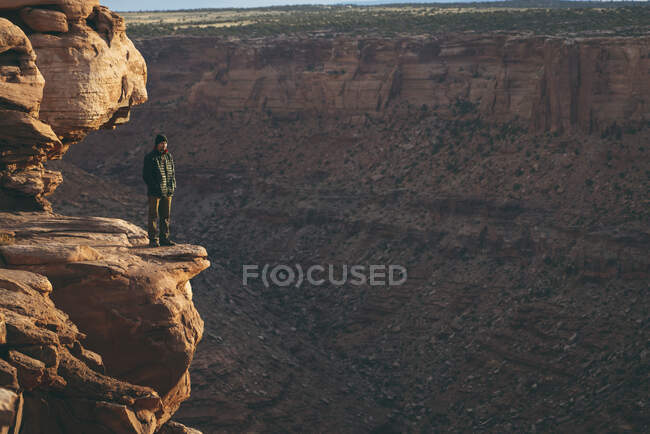 Людина стоїть на краю скелі в національному парку Каньйонлендс. — стокове фото